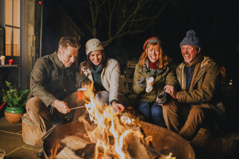 Group of friends early 40s gathered around a fire pit