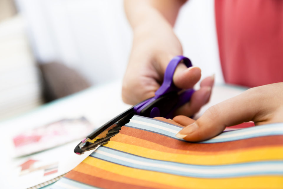 Woman cutting paper for scrapbooking.