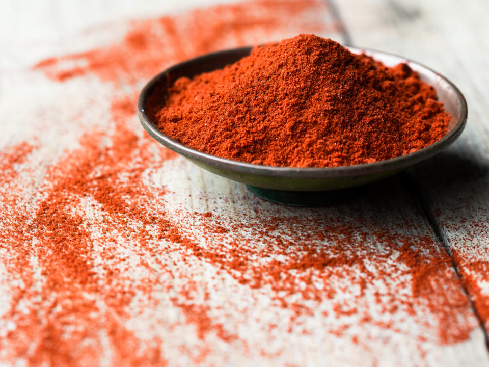 Ground Paprika in a bowl on wooden table