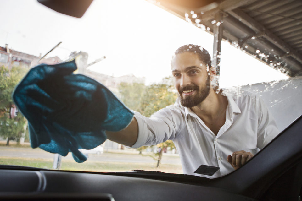 oung man washing windshield