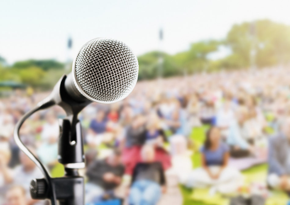 Outdoor music festival or concert: microphone with defocused audience