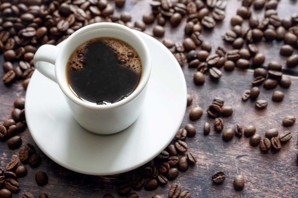 Home made coffee and coffee beans on a brown countertop