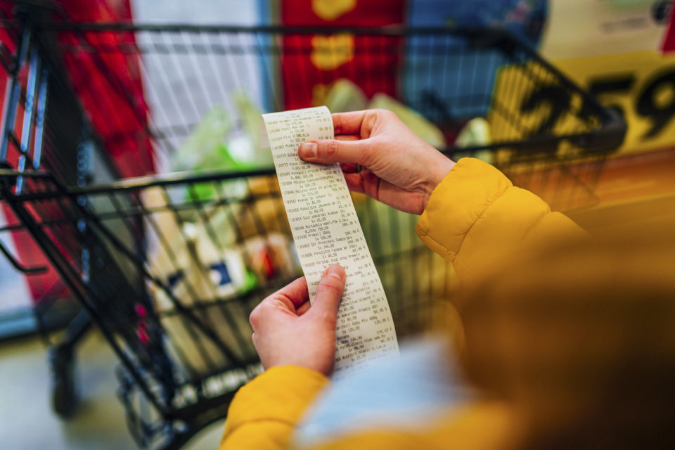 Woman looking at a grocery shopping reciept