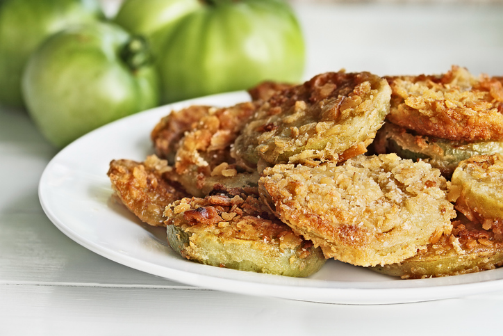 Plate of fresh fried green tomatoes. Tomatoes have been coated in cracker crumbs before frying. Extreme shallow depth of field with selective focus.