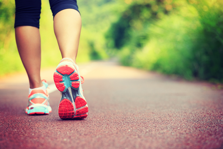 Young fitness female runner legs ready for run on forest trail