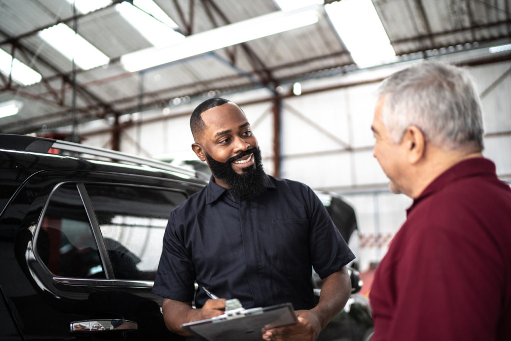 Mechanic man talking to his customer in auto repair