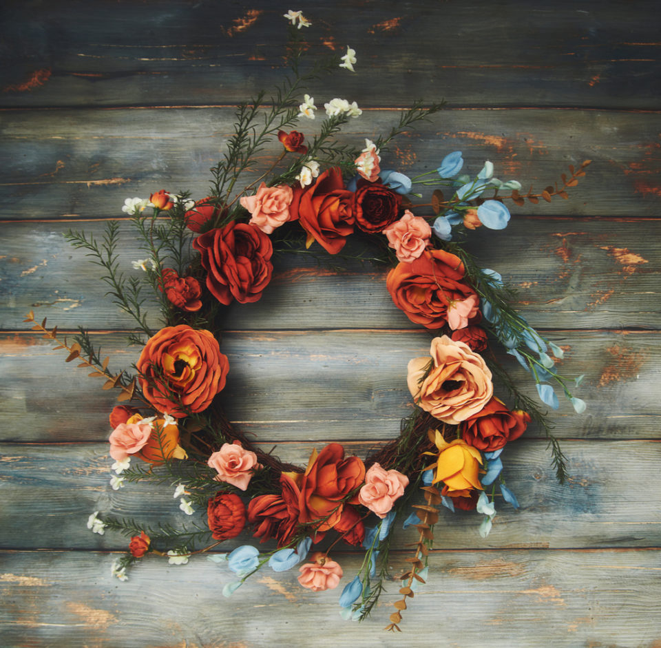 Fall wreath with fall colored roses on a rustic wood background